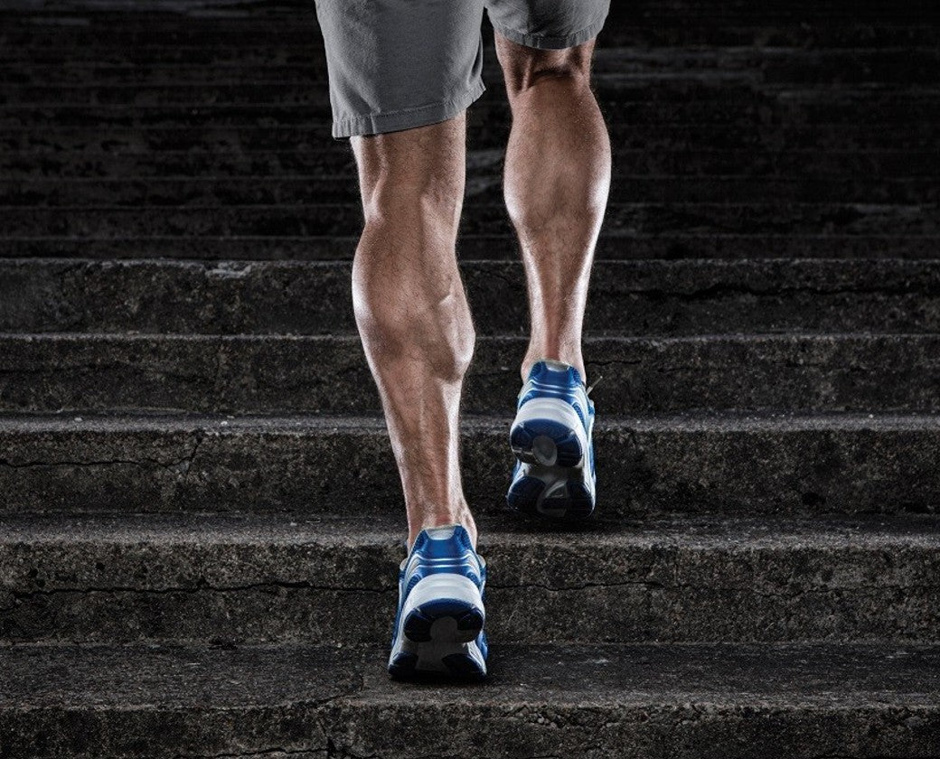 man wearing shorts walking up a flight of stairs outdoors wearing blue runners