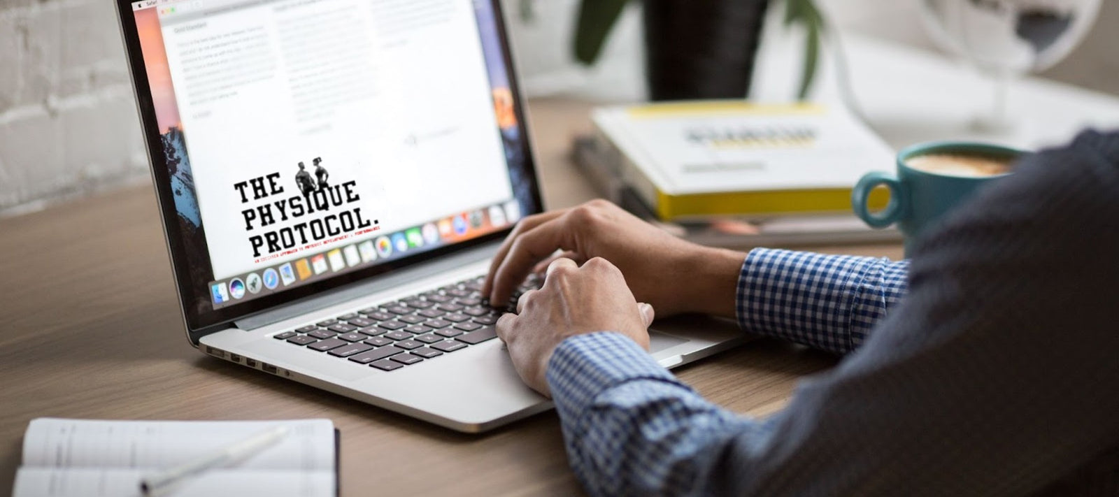 businessman typing on his laptop with a cup of coffee next to him