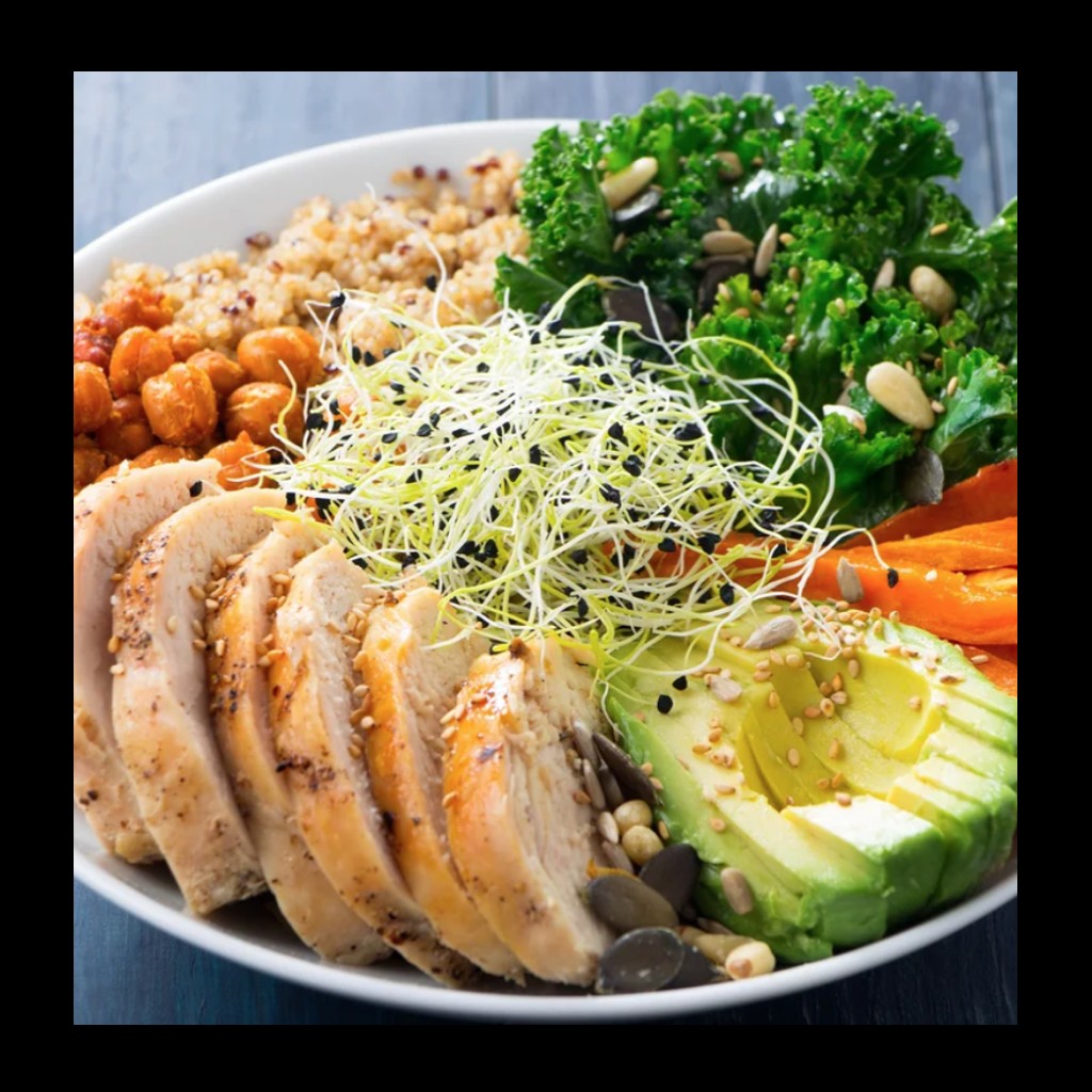 a healthy plate of food consisting of chicken, avocado, chickpeas, kale and carrots.