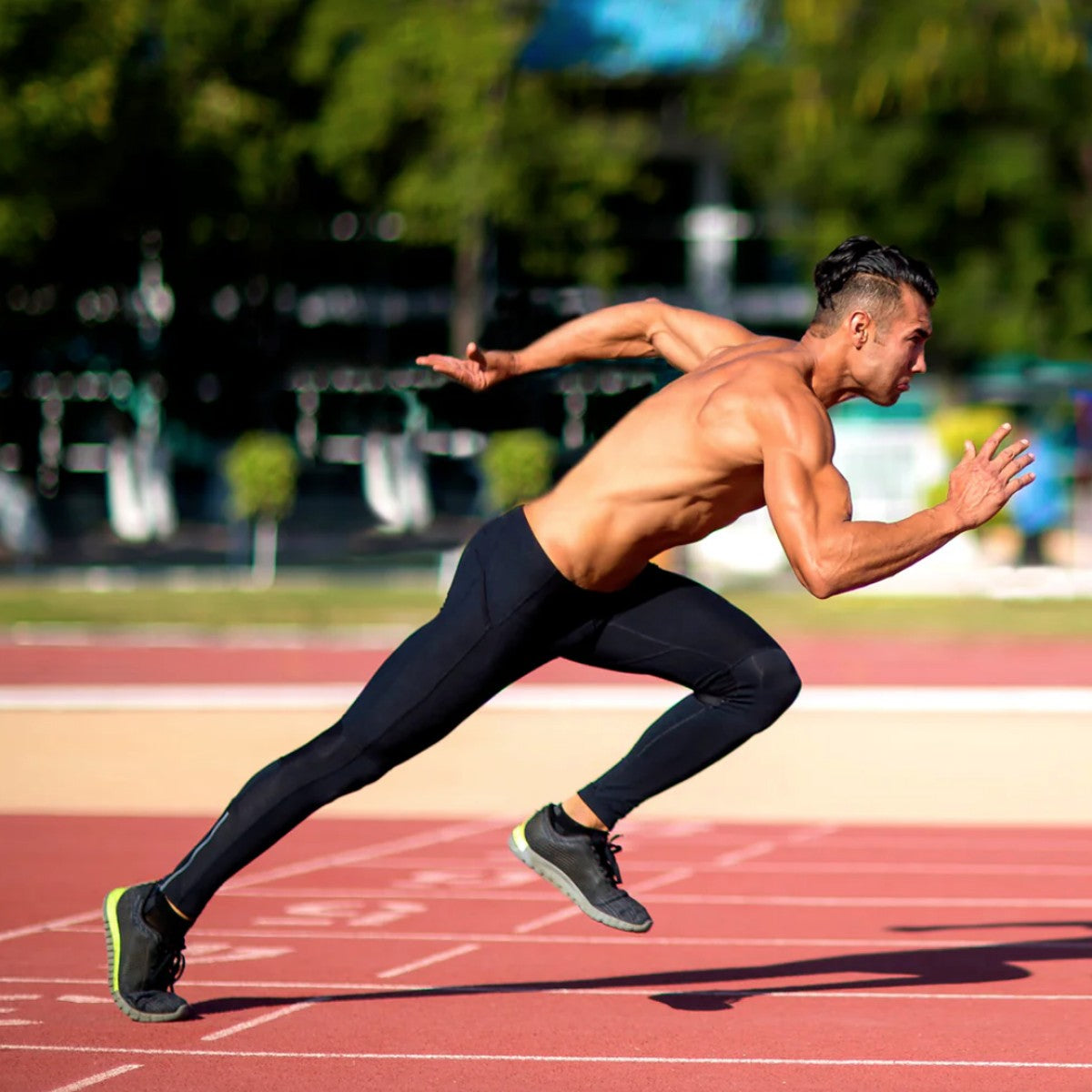 a male sprinter on a sprint track topless.