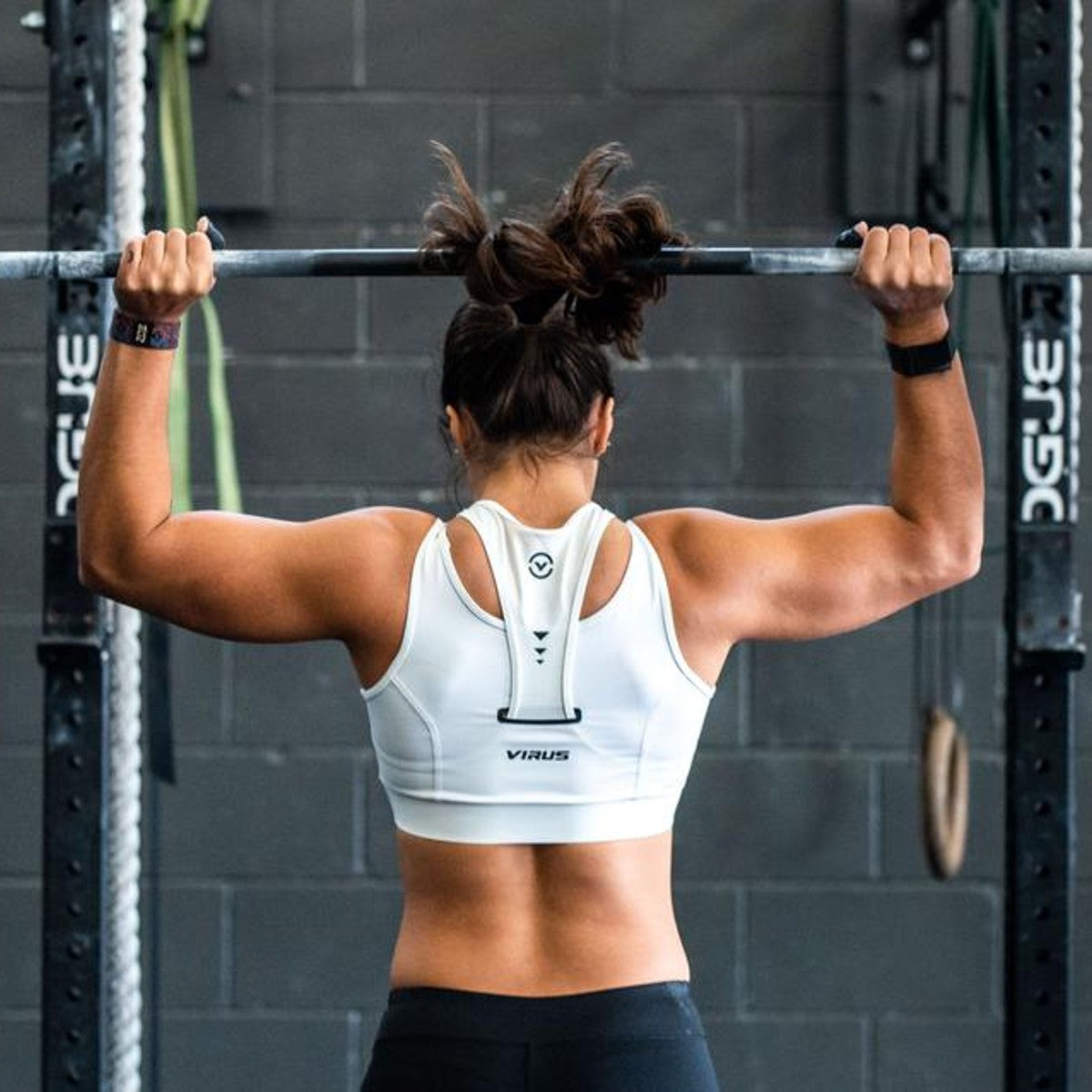 a female fitness athlete barbell shoulder pressing overhead.